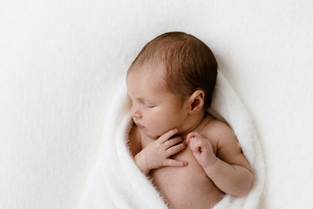 Newborn curled in blanket asleep