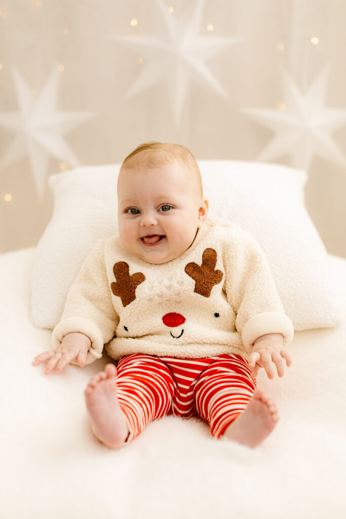 Baby in Christmas outfit with star backdrop