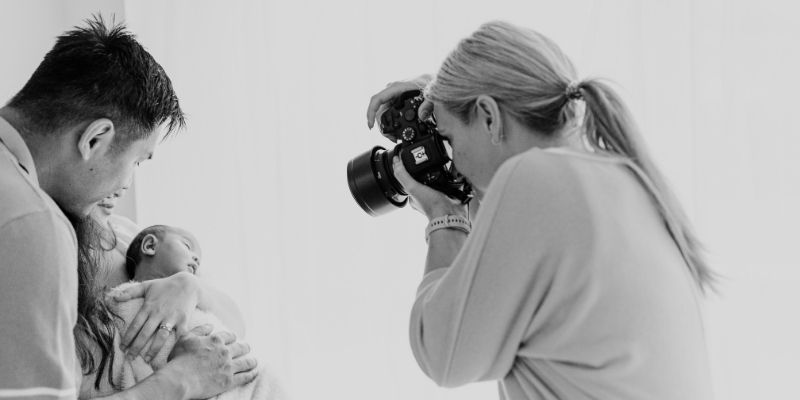 Aby taking a photo of a new Mum, Dad and Baby girl