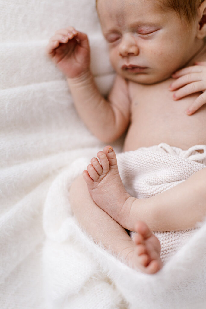 curled sleepy newborn focus on toes