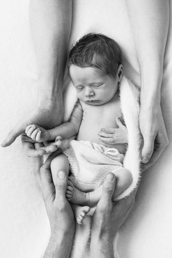 Newborn cradled in Mum and Dads hands
