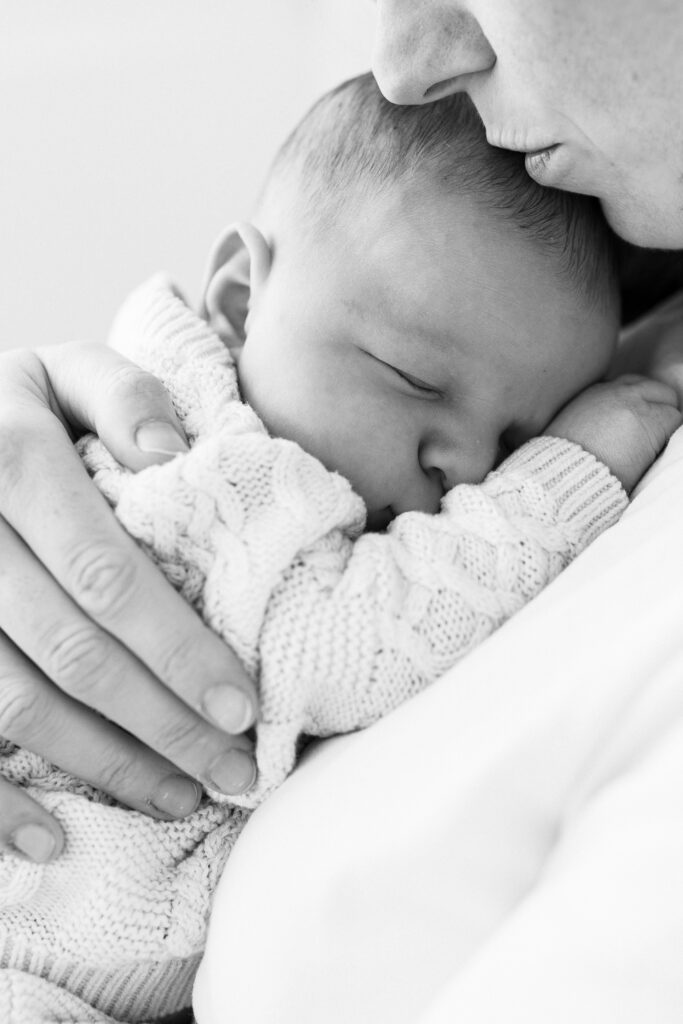 Newborn cuddled on mum's chest. black and white image