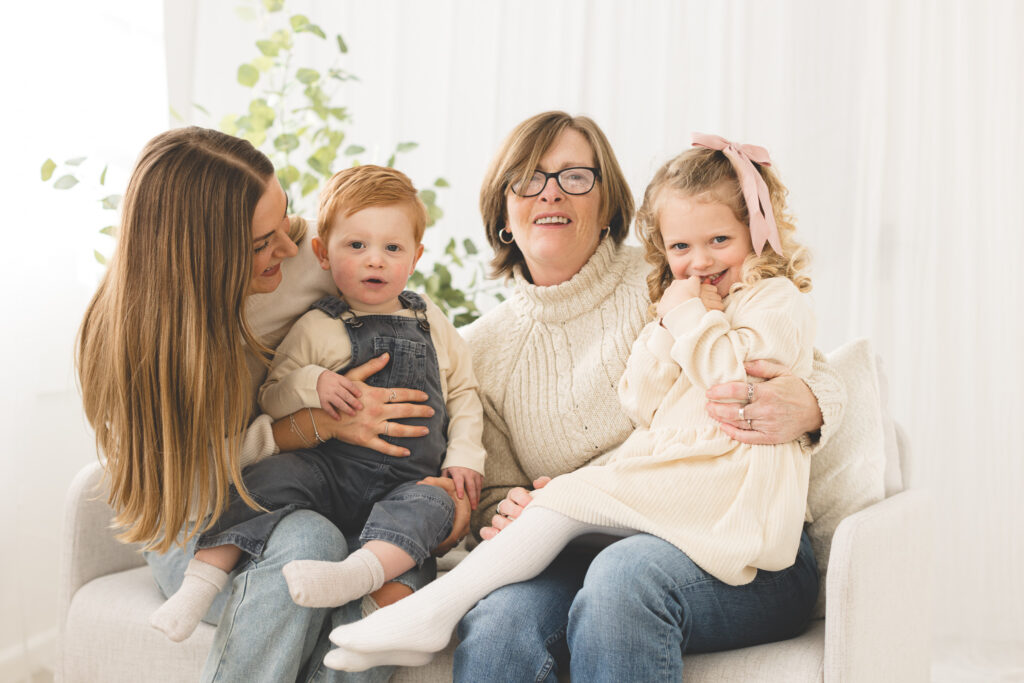 Grandma, Mum and children hugging on sofa