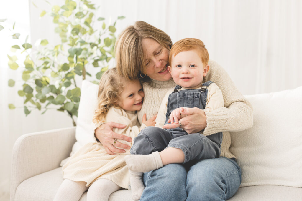 Grandmother having a big hug with baby grandson and grandaughter