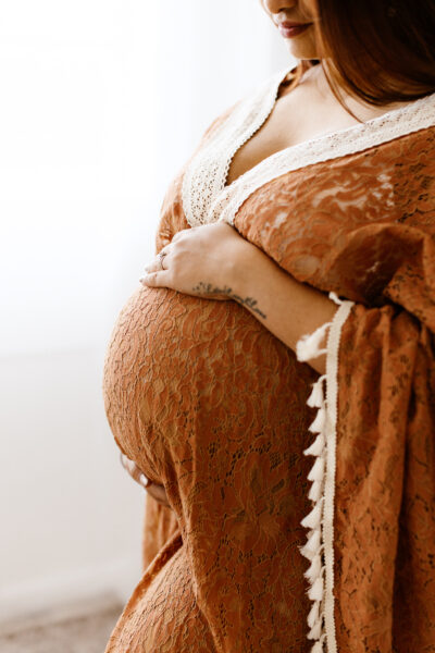 Burnt orange maternity dress on expecting mama