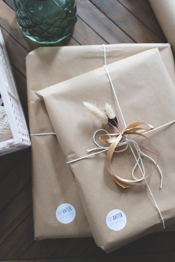 Packaged framed prints in brown paper packaging tied up with string.